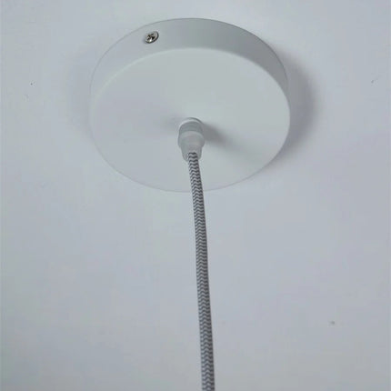 Gros plan sur le diffuseur en verre galet blanc laité de la suspension Helsinki allumée