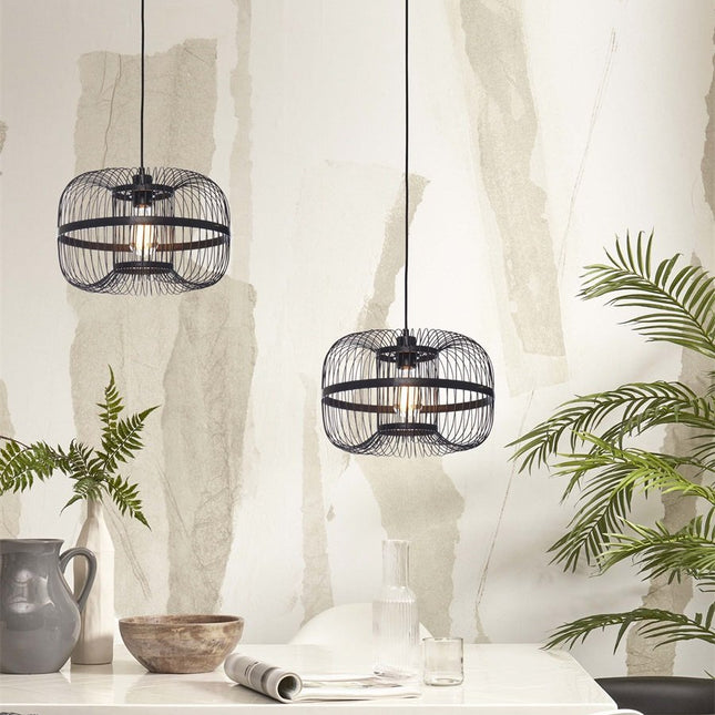 Pair of black woven bamboo Hokkaido pendant lights, lit above a dining table