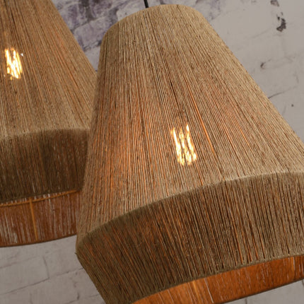 Gros plan sur la texture tressée du jute de l'abat-jour Iguazu, lumière filtrant à travers les fibres
