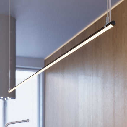 Suspension Ligne Minimaliste noire allumée au-dessus d'une table à manger