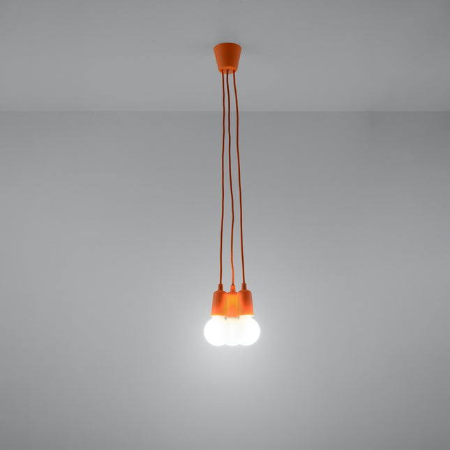 Suspension Ligne Pure orange 3 lampes allumée, lumière douce sur mur clair