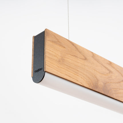 Détail de l'embout anthracite et du bois de chêne de la suspension linéaire