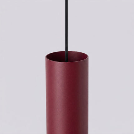 Suspension Long Cylindre 3 bordeaux sur fond coloré, vue de trois quarts