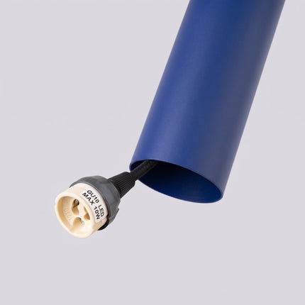 Suspension Long Cylindre bleu outremer sur fond coloré, vue de trois quarts