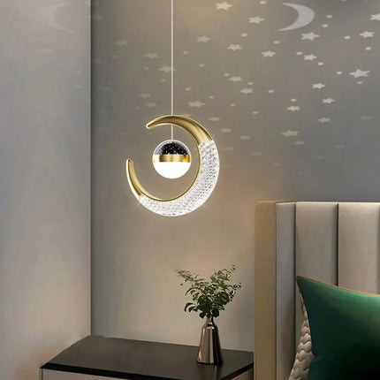 Suspension lune et étoile LED dorée au chevet d'un lit aux coussins verts