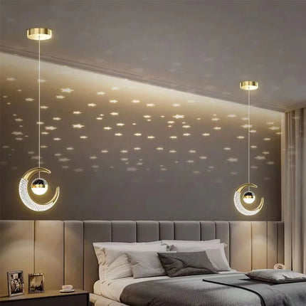 Paire de suspensions lune et étoile LED dorées au-dessus d'un lit double