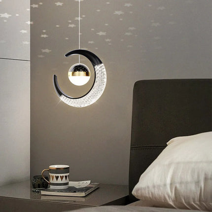 Suspension lune et étoile LED noire allumée près d'un mug au-dessus d'un chevet