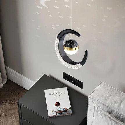 Suspension lune et étoile LED noire projetant des étoiles au-dessus d'une table de chevet