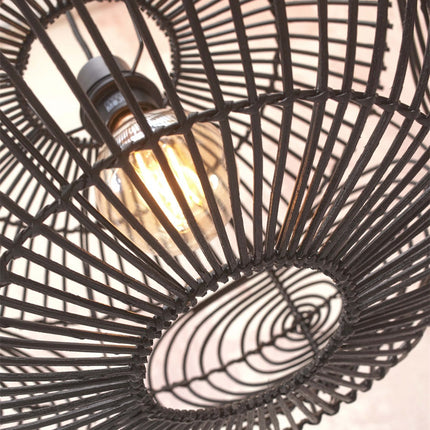 Close-up view of the filament bulb visible through the black rattan weave of the Madeira pendant light