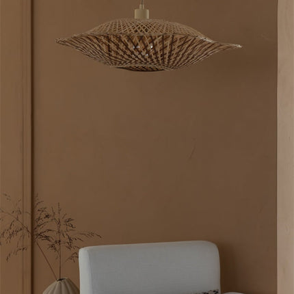 Suspension Madura bambou tressé allumée devant un mur terracotta, effet ondulé du tressage