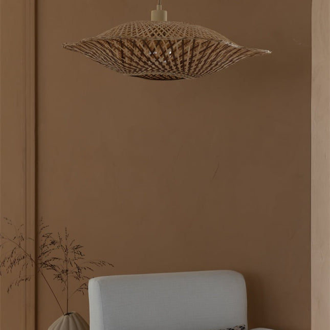 Suspension Madura bambou tressé allumée devant un mur terracotta, effet ondulé du tressage