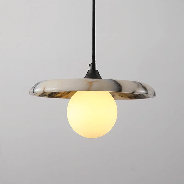 Suspension en marbre blanc veiné avec globe en verre opalin allumé, monture noire, sur fond clair