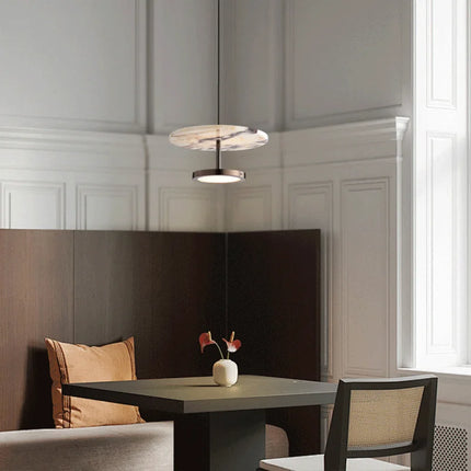 Suspension en marbre au-dessus d'une table à manger dans un intérieur classique et lumineux