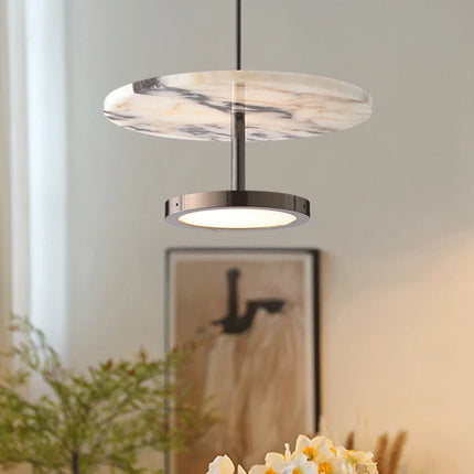 Suspension en marbre naturel allumée au-dessus d'une console, ambiance de salon chaleureuse