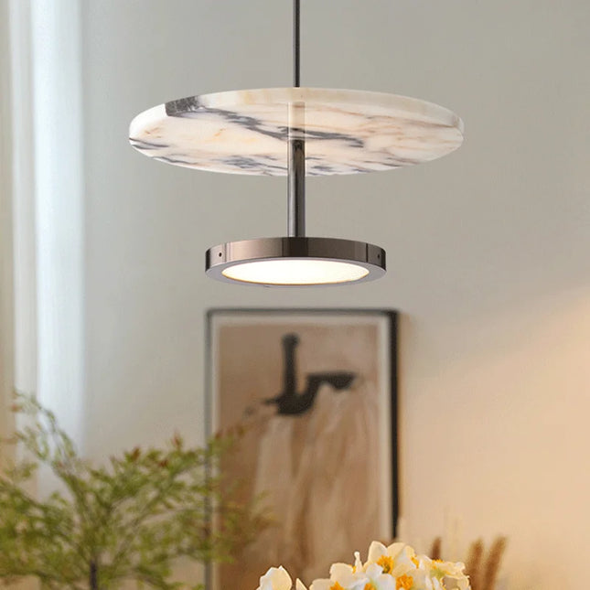 Suspension en marbre naturel allumée au-dessus d'une console, ambiance de salon chaleureuse