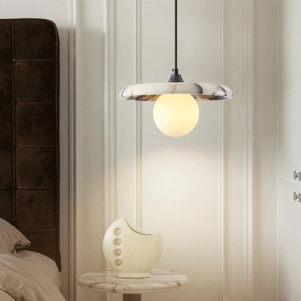 Suspension en marbre blanc et globe opalin près d'une tête de lit en velours brun