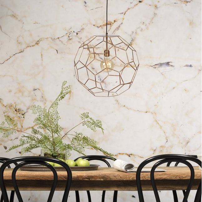 Suspension Marrakesh boule filaire cuivrée au-dessus d'une table à manger en bois