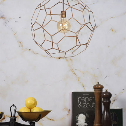 Suspension Marrakesh boule filaire cuivrée devant un mur en marbre veiné
