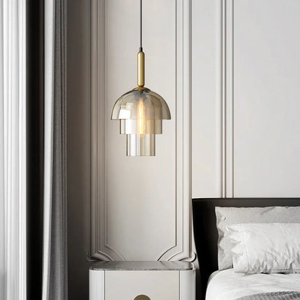 Suspension méduse en verre teinté fumé allumée au-dessus d'un chevet dans une chambre