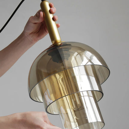 Détail des couches de verre teinté étagées de la suspension méduse tenue à la main
