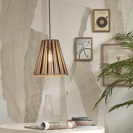 Suspension Merapi en bambou naturel et noir dans un intérieur épuré, à côté de cadres et d'une plante verte.