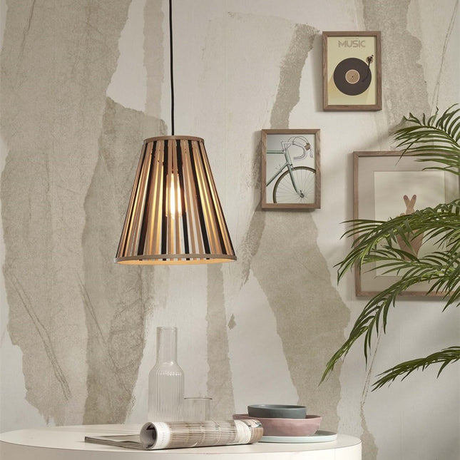 Pendant light Merapi in natural bamboo and black in a clean-lined interior, next to frames and of a green plant.
