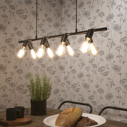 Suspension Miami rampe en fer noir 8 douilles E27 au-dessus d'une table à manger avec papier peint fleuri