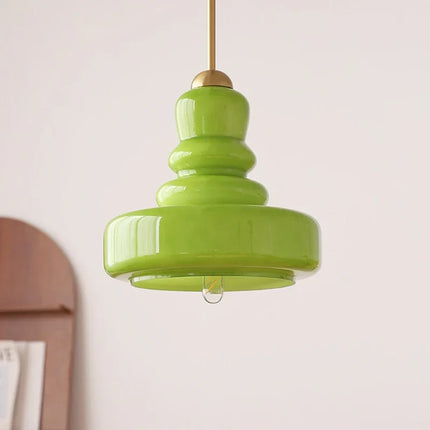 Suspension nordique en verre soufflé vert au galbe étagé et à la tige dorée, sur mur clair