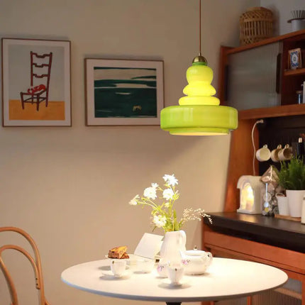 Suspension en verre soufflé vert allumée au-dessus d'une table dans une salle à manger vintage