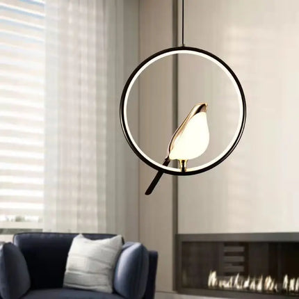 Suspension oiseau doré sur anneau rond noir allumé au-dessus d'un canapé bleu dans un salon lumineux
