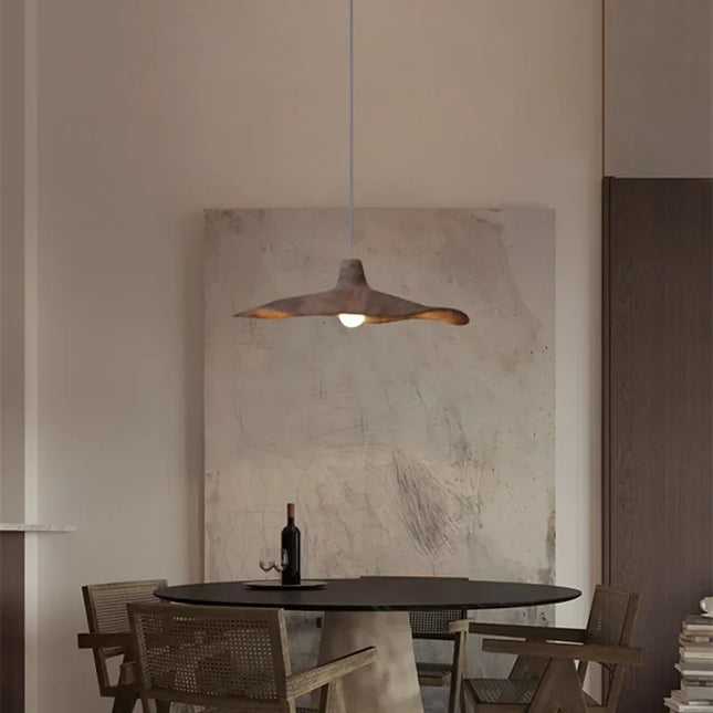 Suspension ondulée en résine éclairant un salon d'une lumière douce