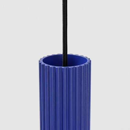 Suspension Oslo 1 Cylindre en Aluminium Cannelé Bleu Outremer, vue sur fond coloré
