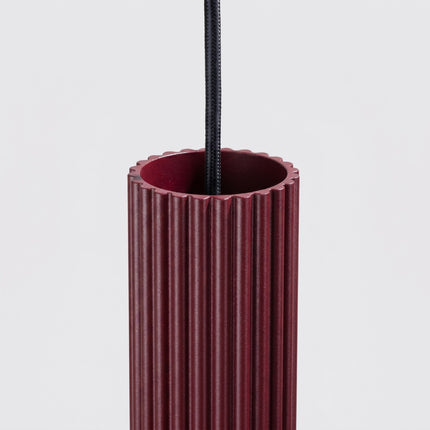 Suspension Oslo 1 Cylindre en Aluminium Cannelé Bordeaux, vue sur fond coloré