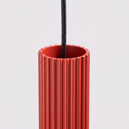 Suspension Oslo 1 Cylindre en Aluminium Cannelé Rouge Vif, vue sur fond coloré