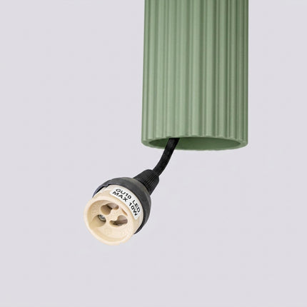 Suspension Oslo 1 Cylindre en Aluminium Cannelé Vert Sauge, vue sur fond coloré