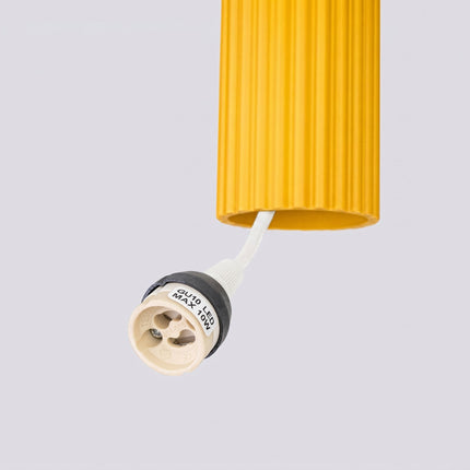 Suspension Oslo 3 cylindres en cascade jaune ambré sur fond coloré, vue de trois quarts