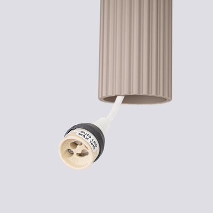 Suspension Oslo 3 Cylindres en Cascade en Aluminium Cannelé Taupe, vue sur fond coloré