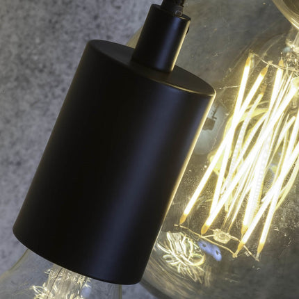 Gros plan sur une douille cylindrique noir mat de la suspension Oslo avec ampoule à filament