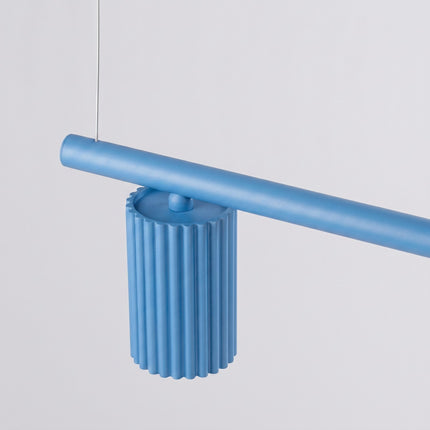 Suspension Oslo poutre 4 cylindres 122 cm bleu ciel sur fond coloré, vue de trois quarts