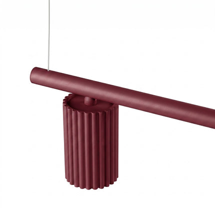 Suspension Oslo poutre 4 cylindres 122 cm bordeaux sur fond coloré, vue de trois quarts