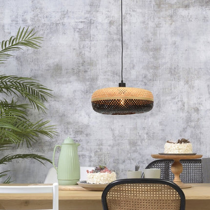 Suspension Palawan en bambou tressé noir et naturel suspendue au-dessus d'une table à manger