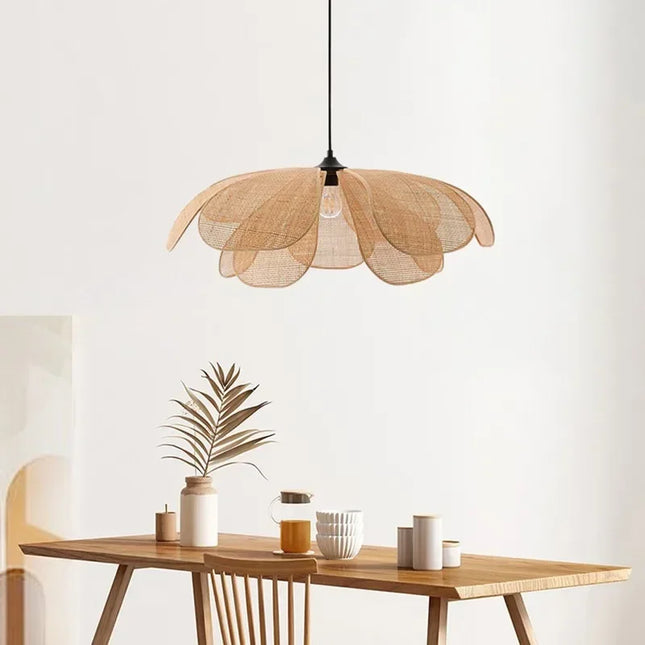 Suspension artisanale pétales en osier tressé au-dessus d'une table en bois clair