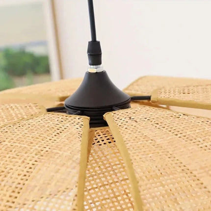 Suspension pétales en osier tressé allumée au-dessus d'un lit dans une chambre apaisante