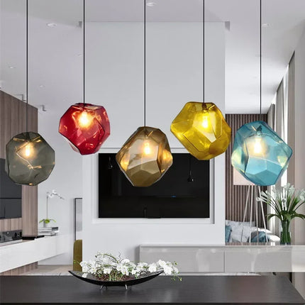 Cinq suspensions pierre en verre coloré (rouge, gris fumé, marron, jaune, bleu) dans un salon