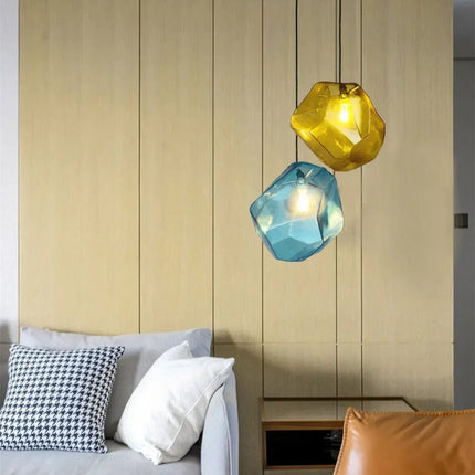 Suspensions pierre en verre jaune et bleu devant un mur de bois dans une chambre