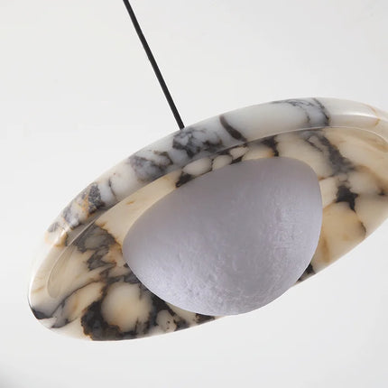 Détail du marbre veiné et de la demi sphère opaline de la suspension Plate