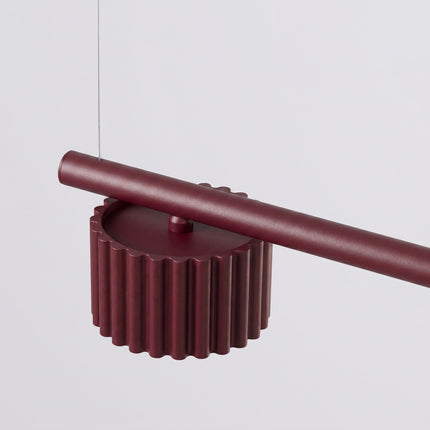 Suspension poutre 4 spots Aura bordeaux, vue sur fond coloré