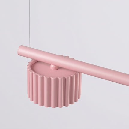 Suspension poutre 4 spots Aura rose poudré, vue sur fond coloré