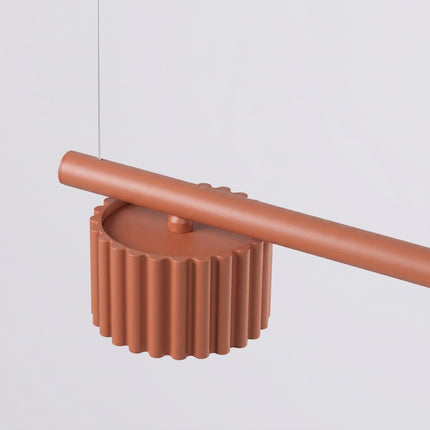 Suspension poutre 4 spots Aura rouge ocre, vue sur fond coloré