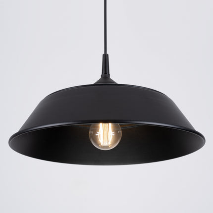 Gros plan sur la suspension Pur Frika noir mat allumee pres d'un mur strie